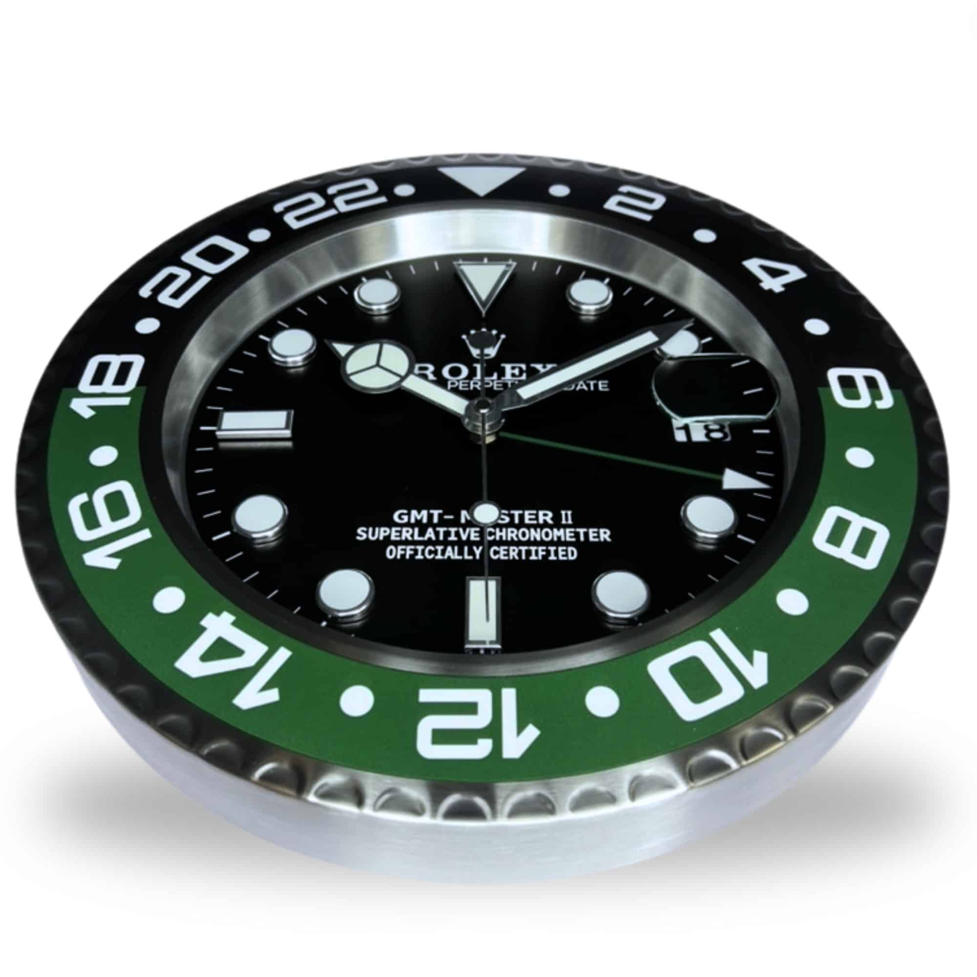 Close-up of a Rolex GMT-Master II watch face with a black and green 24-hour bezel, luminescent hour markers, and a date window at 3 o'clock showing the 18th, set against a white background.