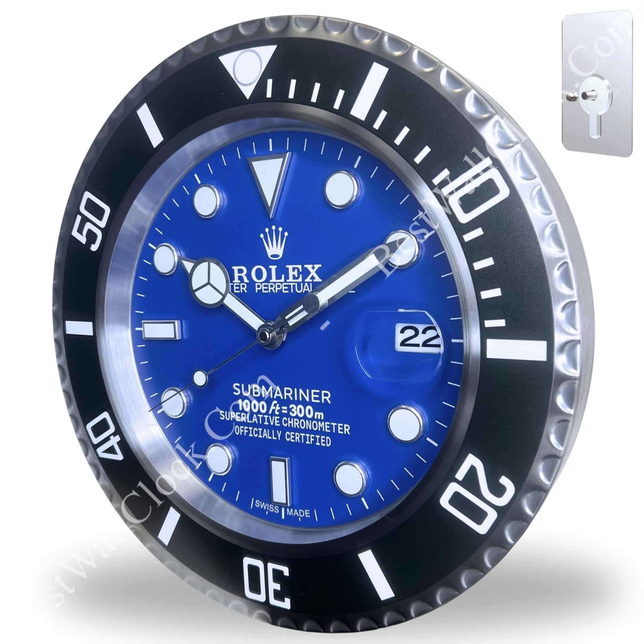 Close-up of a Rolex Submariner wall clock with a blue dial, black bezel with white markings, showing the date as 22 and attached to a mounting plate with a keyhole slot.