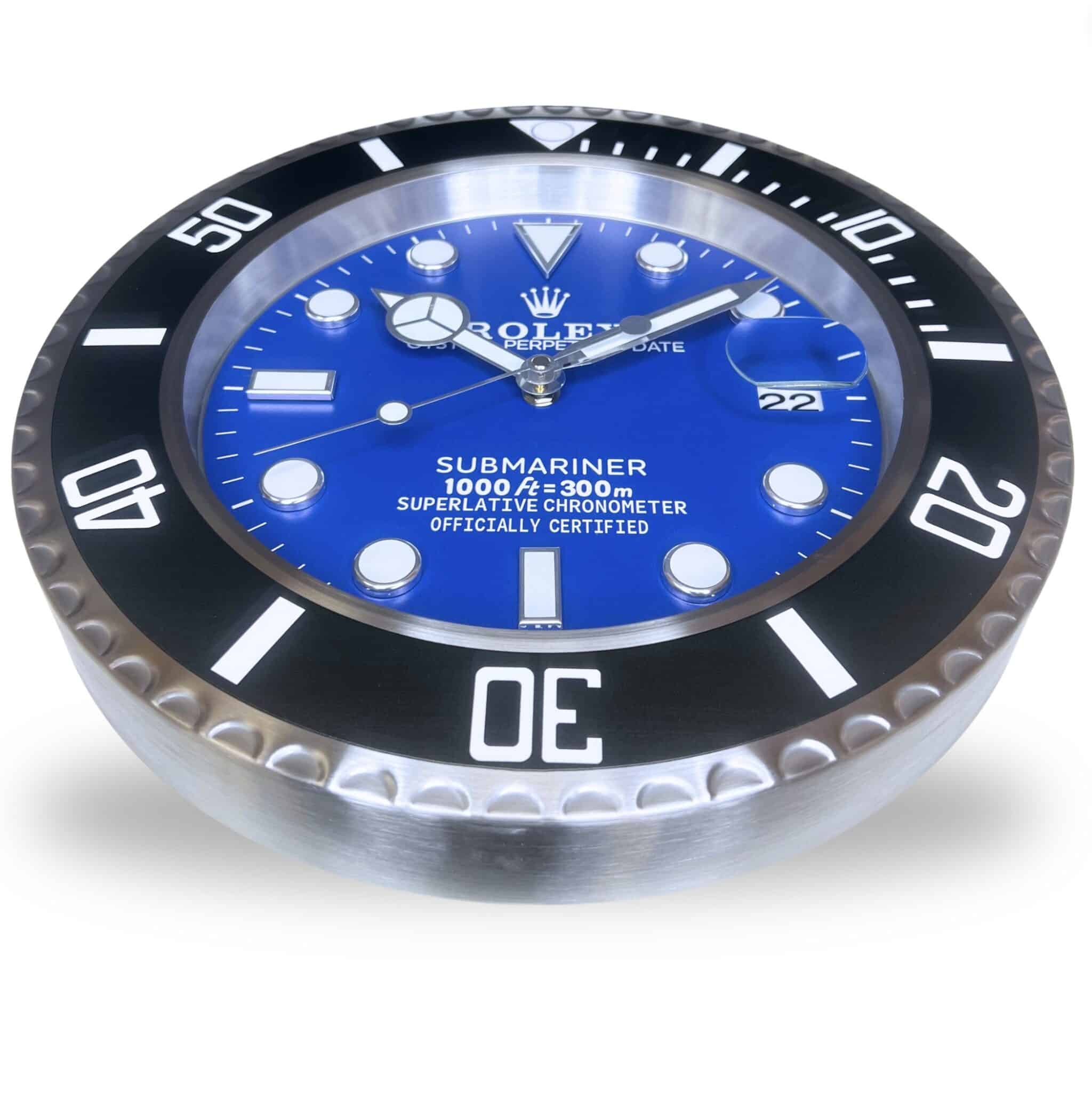 Close-up of a blue Rolex Submariner watch face with a black bezel displaying numbers in white and luminous hour markers, showing the date as the 22nd, against a white background.