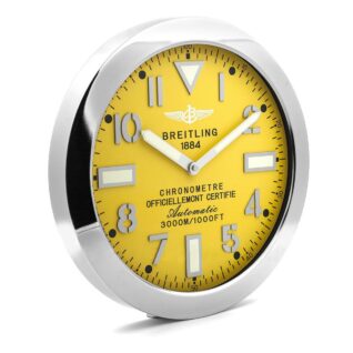 A Breitling wall clock with a bold yellow dial, large silver-tone numerals, thick hands, and a polished stainless steel bezel.