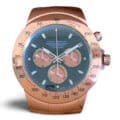 A Rolex Daytona-inspired wall clock with a rose gold case, tachymeter bezel, green dial, pink subdials, chronograph pushers, and luminous markers.
