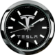 The Tesla Wall Clock is displayed on a black wall.