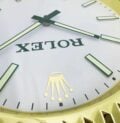 A close up of a ROLEX WALL CLOCK - GOLD OYSTER DATEJUST - GOLD - RL212 with the word "ROLEX" on it at Wimbledon.