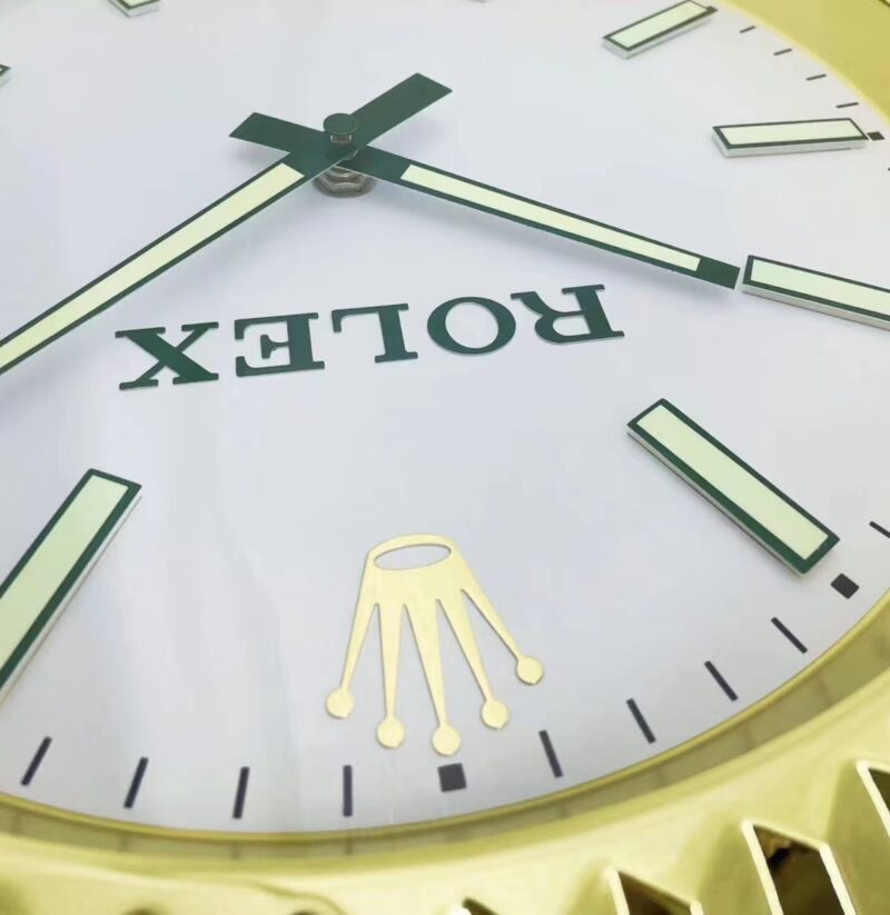 A close up of a ROLEX WALL CLOCK - GOLD OYSTER DATEJUST - GOLD - RL212 with the word "ROLEX" on it at Wimbledon.