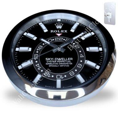 Close-up of a black and silver Rolex wall clock featuring the Sky-Dweller Oyster Perpetual design with white hour markers and silver clock hands.