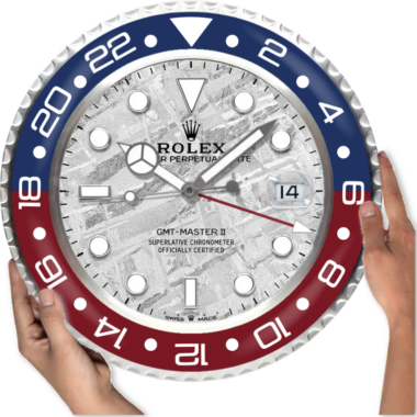 Hands adjusting a large wall clock designed like a Rolex GMT Master 2 '3285' Edition watch.