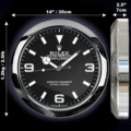 Front and side views of a Rolex Oyster Perpetual Explorer wall clock with dimensions: diameter 14 inches (35 cm), depth 2.5 inches (7 cm), and weight 1.2 kg (2.61 lb), featuring a black dial with luminous hour markers and hands, including large 3, 6, and 9 numerals and a sweeping second hand.