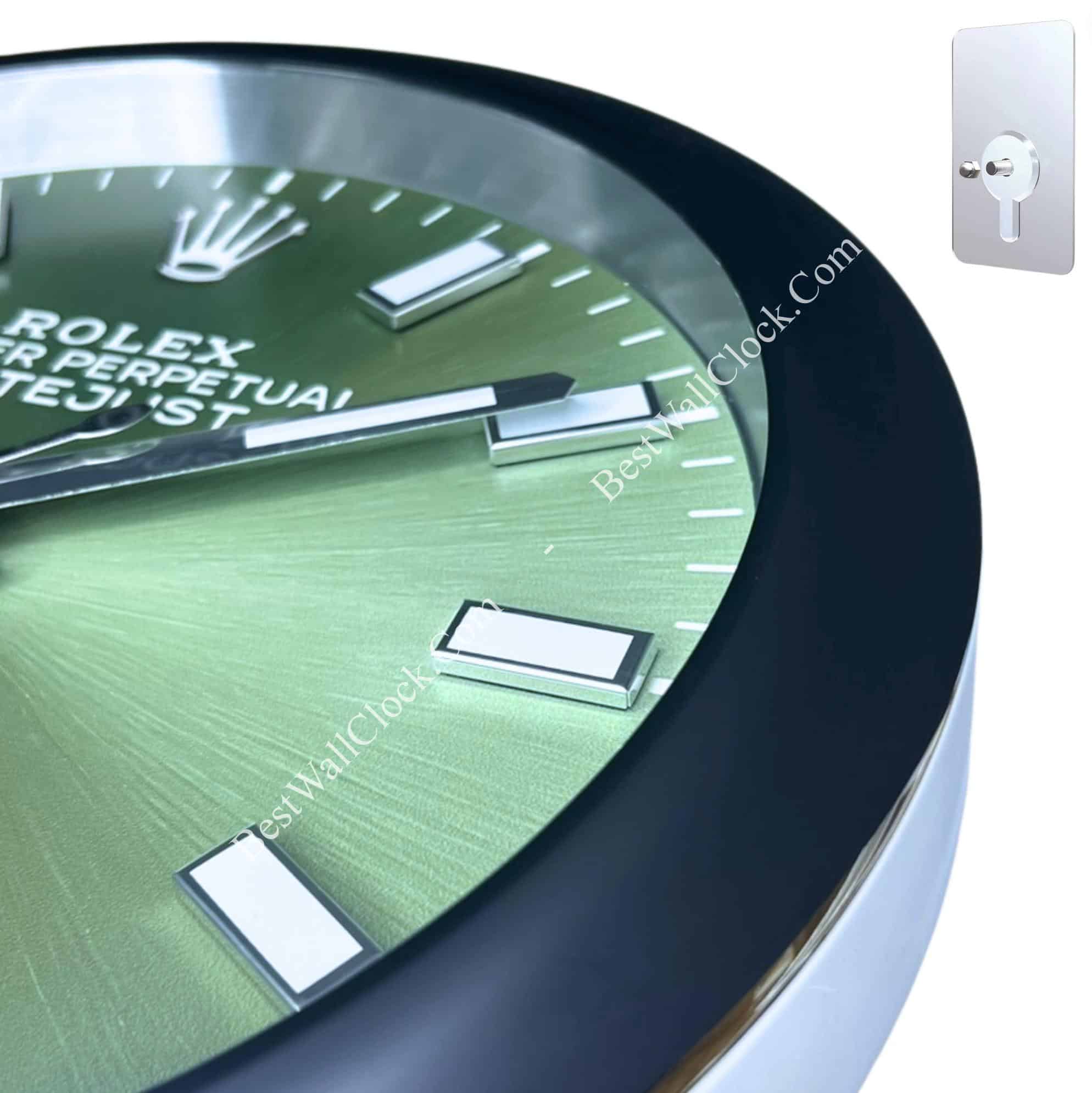 Close-up of a green Rolex Oyster Perpetual Datejust watch face with silver rectangular hour markers and hands, featuring a black outer rim.
