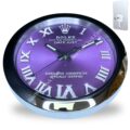 Round wall clock with a purple face and silver Roman numerals, black hands, and a metallic rim, styled like a Rolex Oyster Perpetual Datejust watch, showing time at 10:10.