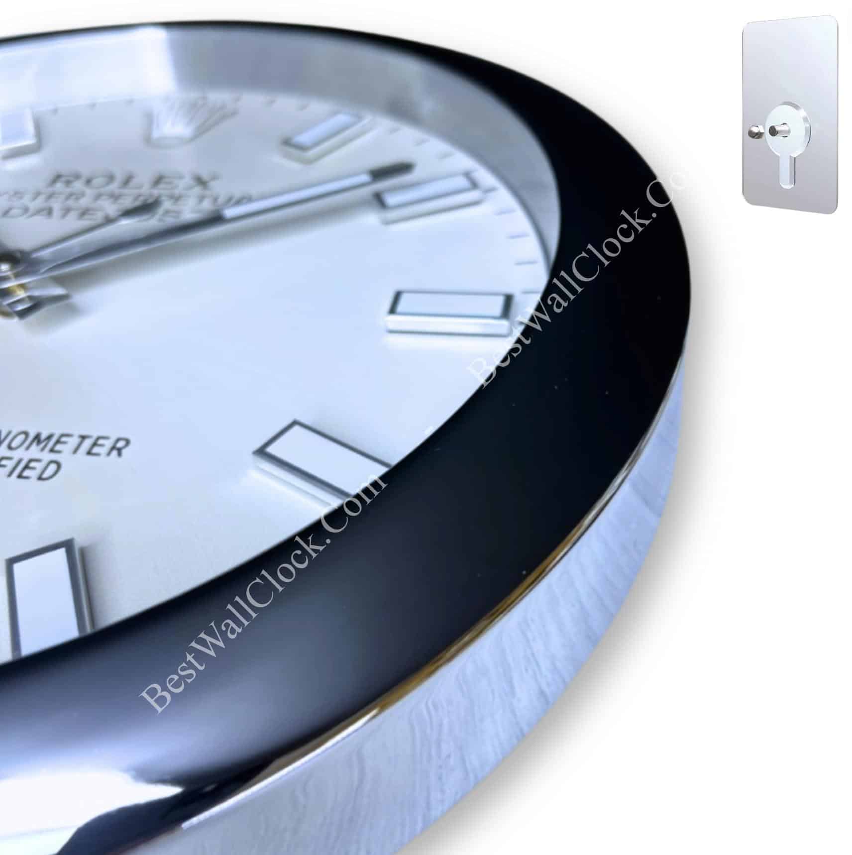 Close-up of a white Rolex clock face with silver hour markers and hands, a black outer bezel, and a shiny silver edge, shown with a mounting bracket on a white background.