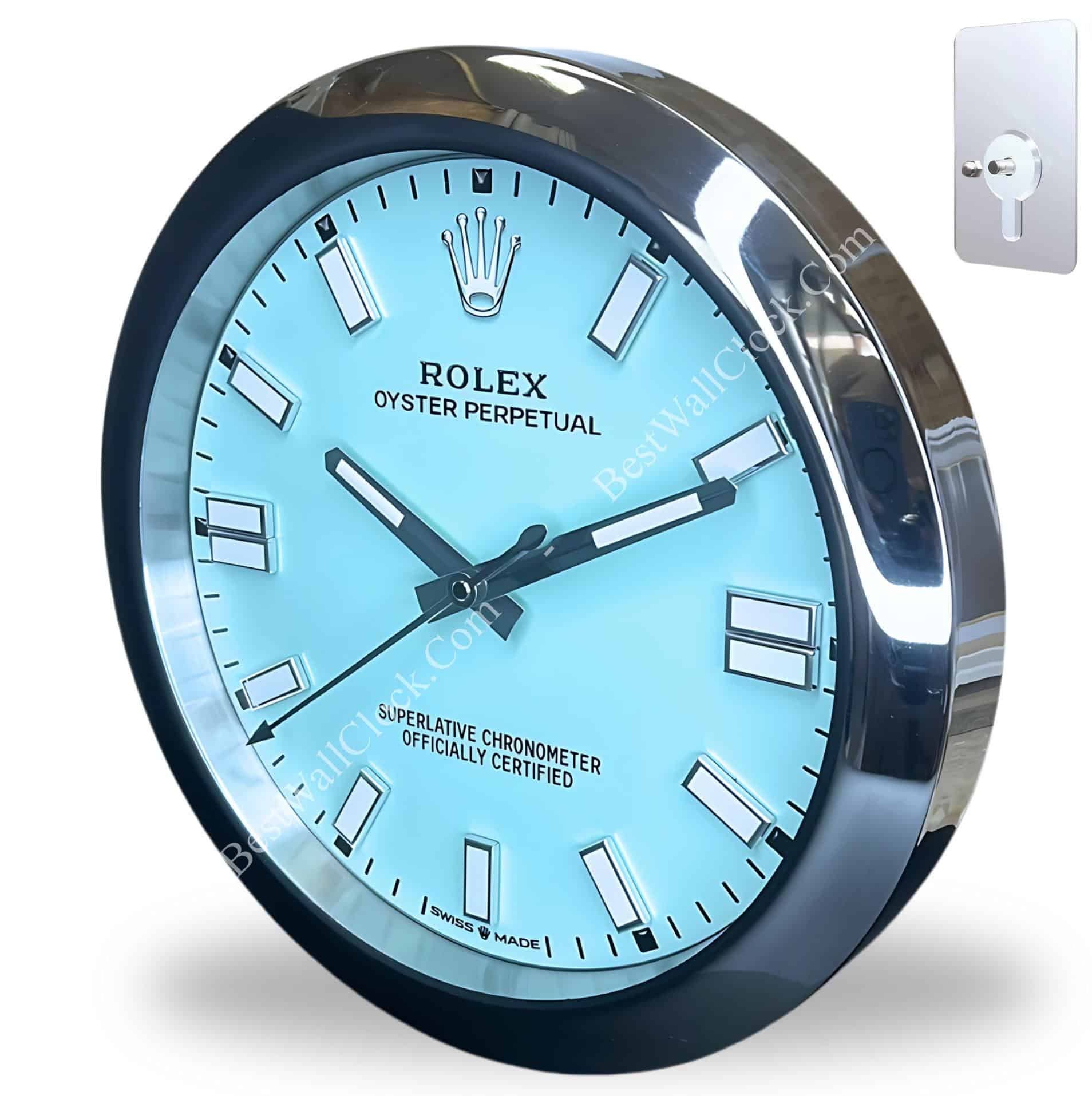 Wall clock designed like a Rolex Oyster Perpetual watch with a light blue face and silver markers, encased in a shiny metallic frame with a keyhole mounting plate beside it.