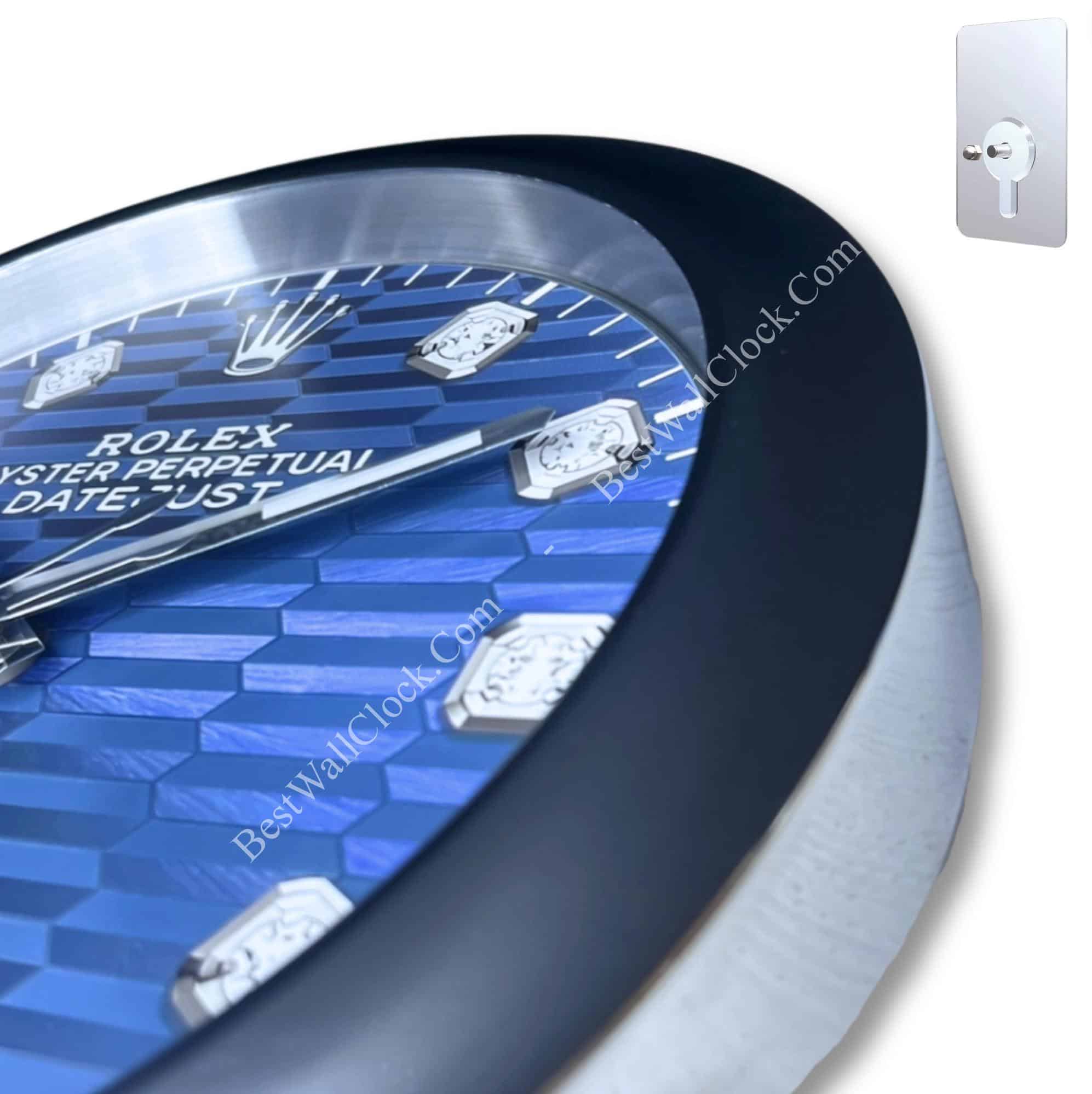 Close-up of a blue Rolex Oyster Perpetual Datejust watch face with silver hour markers and hands, featuring a detailed patterned dial and black bezel.