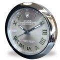Rolex well clock featuring a round face with silver Roman numerals on a grey dial and a shiny metallic frame