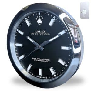 Close-up of a black and silver Rolex wall clock with white hour markers and Rolex logo, featuring the text 'Oyster Perpetual' and 'Superlative Chronometer Officially Certified', mounted on a white background with a metal wall hook