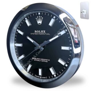 Close-up of a black and silver Rolex wall clock with white hour markers and Rolex logo, featuring the text 'Oyster Perpetual' and 'Superlative Chronometer Officially Certified', mounted on a white background with a metal wall hook