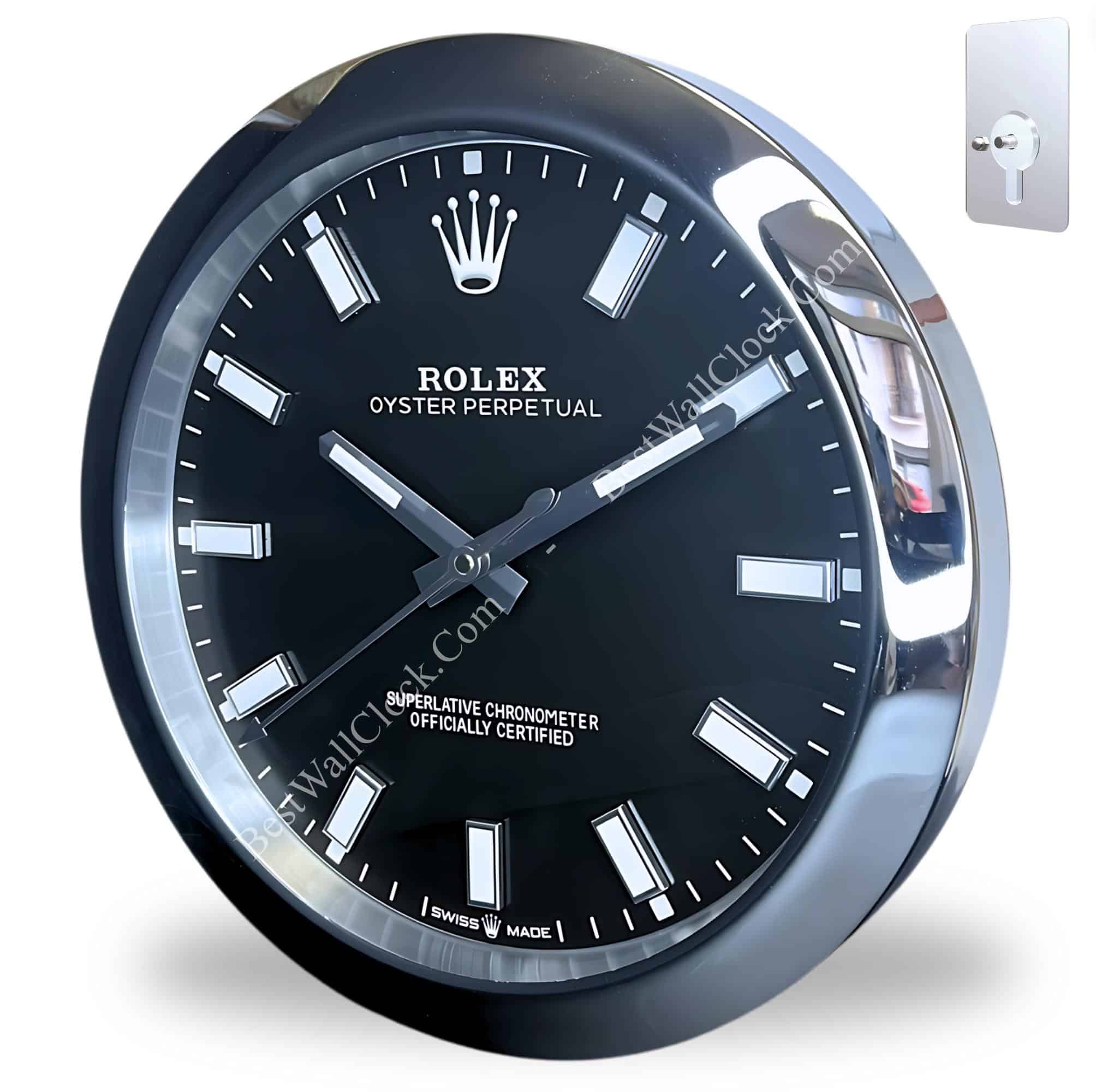 Close-up of a black and silver Rolex wall clock with white hour markers and Rolex logo, featuring the text 'Oyster Perpetual' and 'Superlative Chronometer Officially Certified', mounted on a white background with a metal wall hook