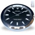 Rolex wall clock with a black dial and silver hour markers set in a round silver frame showing the time 10:10:38, mounted on a light background with a metal wall hook in the corner