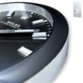 Close-up of a black and silver rolex wall clock showing the ROLEX logo and oyster perpetual text on its face, featuring metallic hour markers and hands.