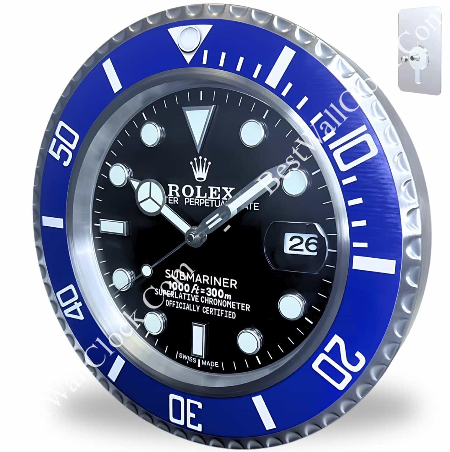 A rolex wall clock styled like a Submariner watch with a black face, white markers, and a blue bezel showing the date 26, mounted on a white background