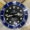 Close-up of a Rolex Submariner watch face with a blue bezel showing the date as 14