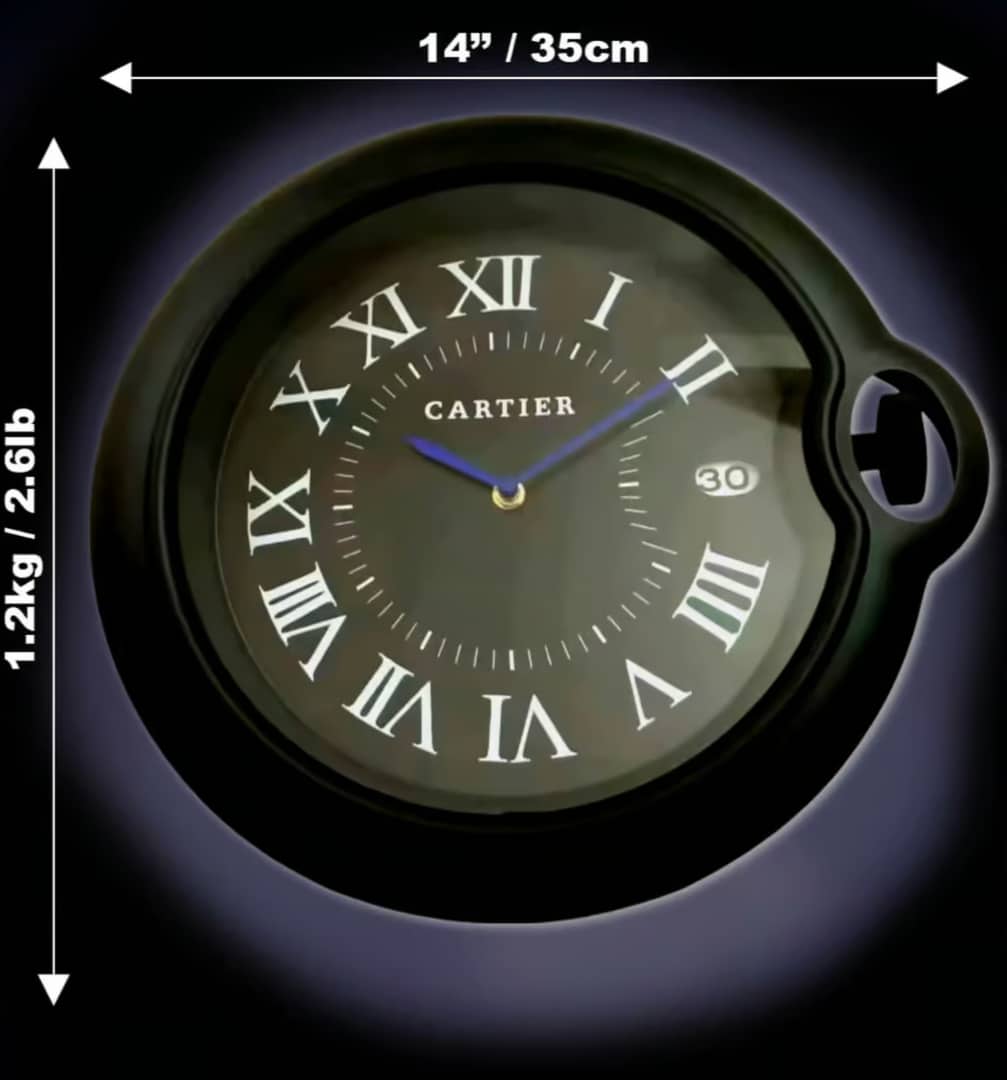 Rolex wall clock styled like a Cartier wristwatch with Roman numerals, measuring 14 inches (35 cm) in diameter and weighing 1.2 kg (2.6 lb) against a dark background.