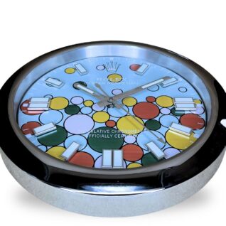 Rolex wall clock with a colourful dial featuring various sized circles in yellow, red, green, pink, and blue, encased in a shiny silver frame with white hour markers and hands.