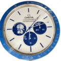 Rolex wall clock styled as an Omega Speedmaster Professional with a blue tachymetre bezel, white face, and blue subdials including a 50th anniversary Snoopy illustration.