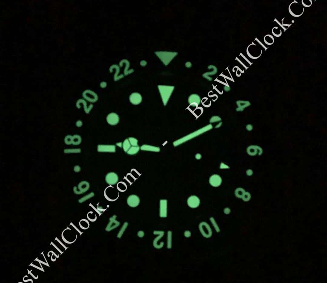 Glow-in-the-dark face of a rolex wall clock showing 24-hour time markings and luminous hands against a black background with BestWallClock.Com watermark
