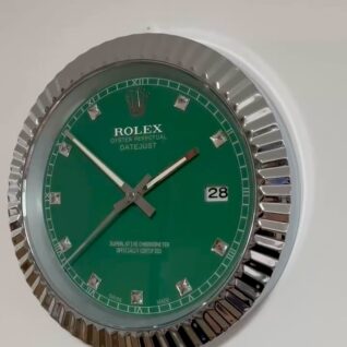 Close-up of a green Rolex Oyster Perpetual Datejust wristwatch face with silver hour markers and hands, showing the date as 28, against a white background.