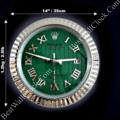 Round wall clock with a green face and silver Roman numerals, silver fluted frame, and white hour, minute, and second hands, showing the time as 3:48:30, with a date window displaying the number 18, and dimensions of 14 inches (35 cm) in diameter and weight of 1.2 kg (2.6 lb).