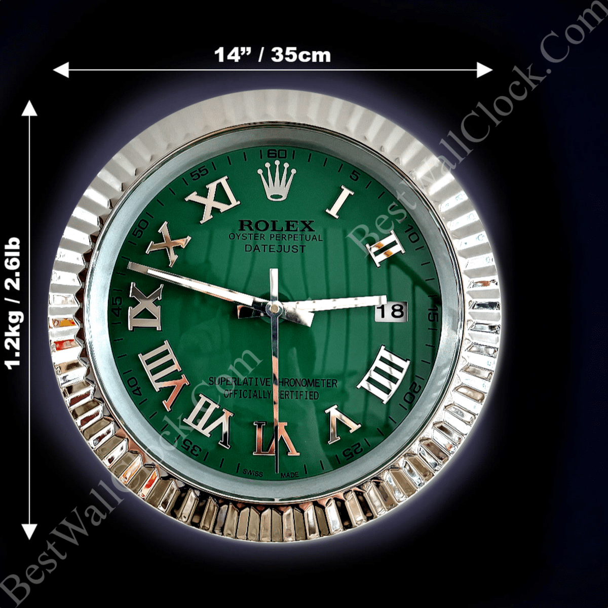Round wall clock with a green face and silver Roman numerals, silver fluted frame, and white hour, minute, and second hands, showing the time as 3:48:30, with a date window displaying the number 18, and dimensions of 14 inches (35 cm) in diameter and weight of 1.2 kg (2.6 lb).