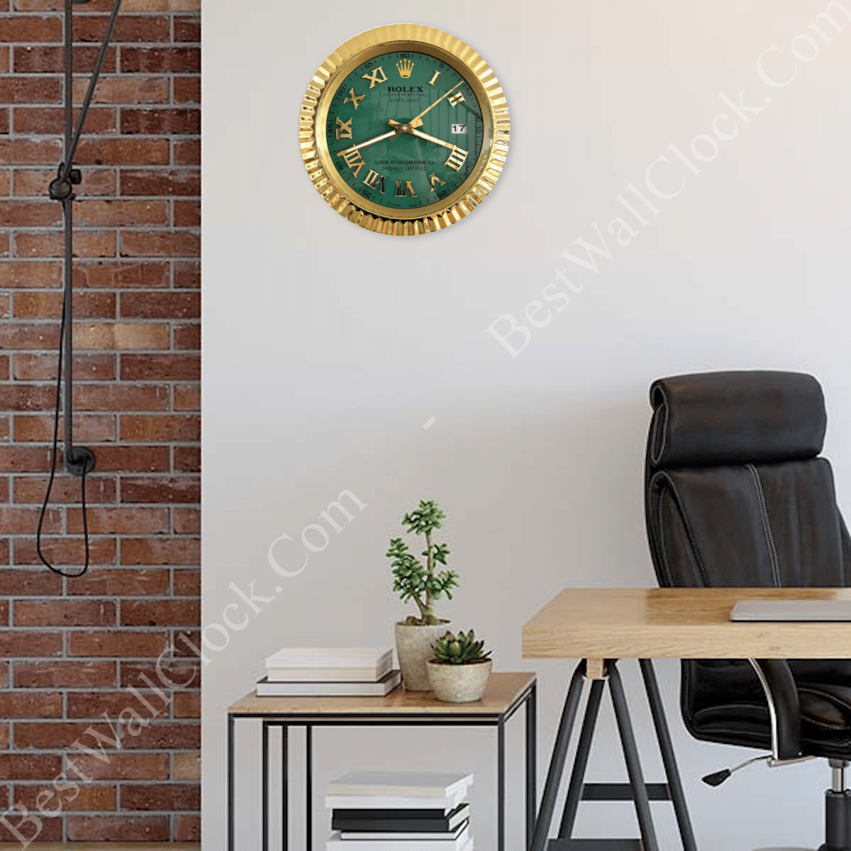 Modern office corner with a black leather chair, wooden desk, side table with small potted plants and books, and a green and gold Rolex-style wall clock with Roman numerals on a light wall next to an exposed brick section.