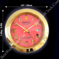 Gold-framed Rolex Datejust wall clock with a red face, gold Roman numerals, and a date display showing the 17th, measuring 14 inches (35 cm) in diameter and weighing 1.2 kg (2.6 lb)