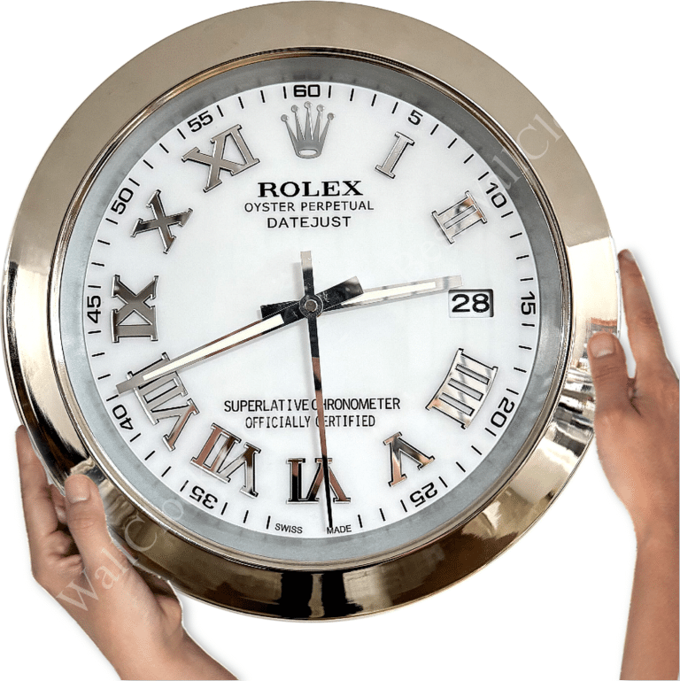 Hands holding a large Rolex wall clock with a white face, silver Roman numerals, and a date window showing 28, framed in a reflective silver bezel