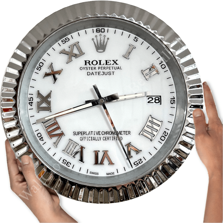 Close-up of a round wall clock designed like a Rolex Oyster Perpetual Datejust watch face with Roman numerals and a date window showing the 28th, held by two hands on either side against a white background.