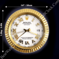 Round gold wall clock styled like a Rolex Datejust watch face with roman numerals and a fluted bezel, measuring 14 inches (35 cm) in diameter and weighing 1.2 kg (2.6 lb).