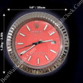 Rolex wall clock with a red face, silver hour markers and hands, and a silver fluted bezel, measuring 14 inches (35 cm) in diameter and weighing 1.2 kg (2.6 lb) with date display at 3 o'clock and text reading Rolex Oyster Perpetual Datejust Superlative Chronometer Officially Certified.