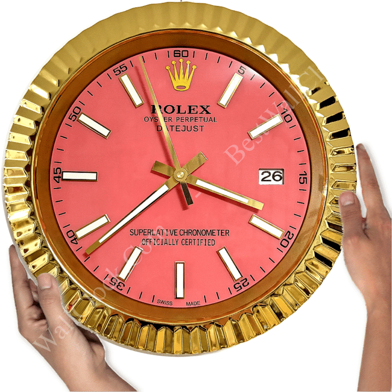 Gold-framed Rolex wall clock with a pink face, white hour markers, and gold hands, held by two hands at the sides, showing the time as 3:39:59.