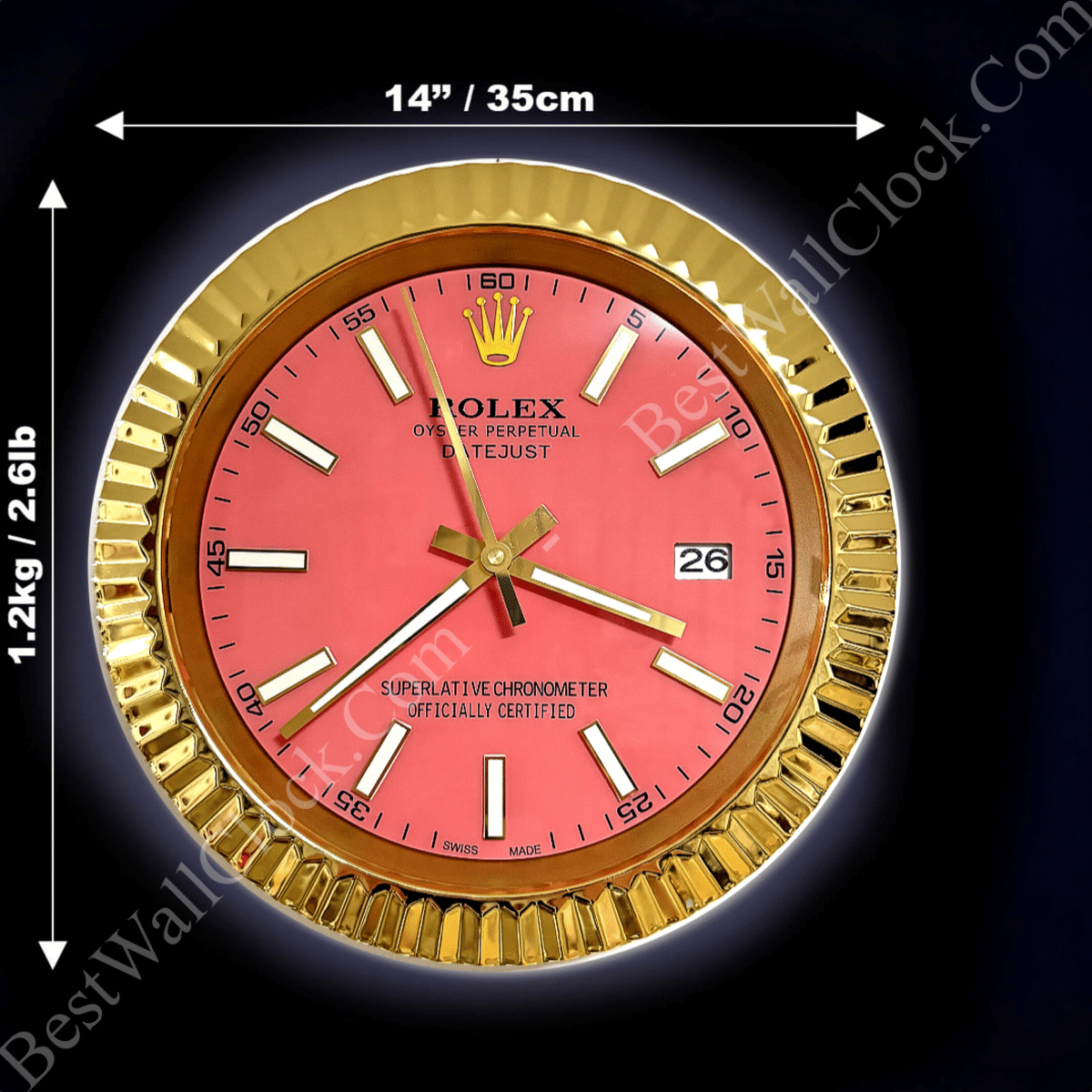 Round wall clock with a gold fluted frame, pink face, gold hour and minute hands, white rectangular hour markers, and a date window at 3 o'clock, measuring 14 inches (35 cm) in diameter and weighing 1.2 kg (2.61 lb).
