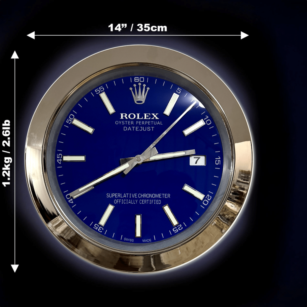 Rolex Oyster Perpetual Datejust wall clock with a blue face and silver markers inside a shiny gold frame, accompanied by dimension arrows indicating 14 inches (35 cm) diameter and 1.2 kg (2.6 lb) weight.