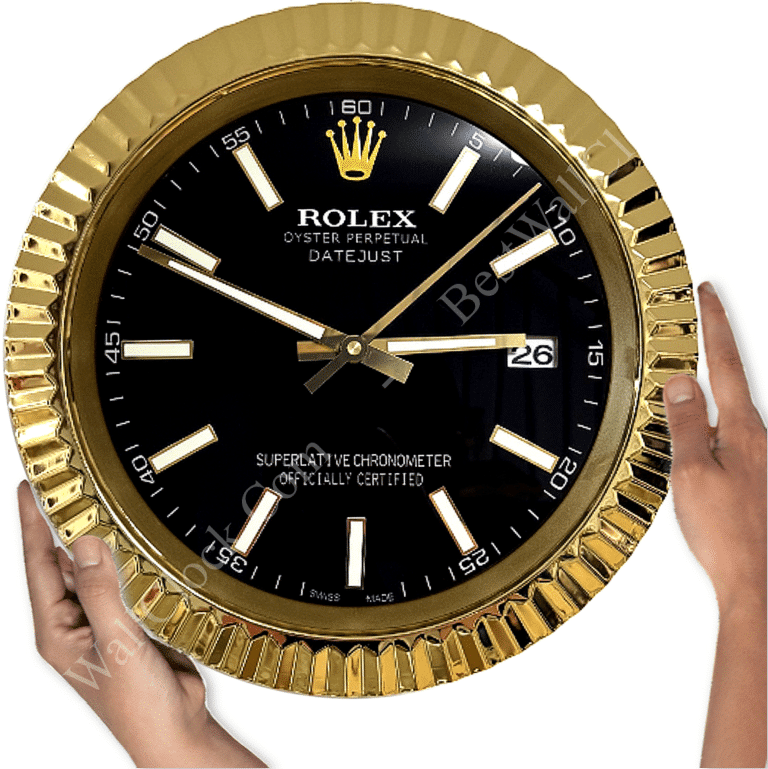 Hands holding a large wall clock designed to resemble a gold Rolex Oyster Perpetual Datejust watch face with black dial and gold markers