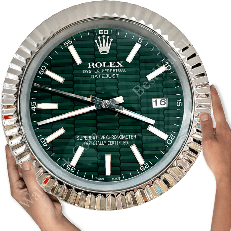 Close-up of a round Rolex Oyster Perpetual Datejust wall clock with a green patterned dial, silver hour markers and hands, held by two hands against a white background, showing the date 16 and time 10:44:47.