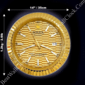 Round gold wall clock resembling a Rolex watch face with textured pattern, white hour markers, and white hands, showing the date as 16, with dimensions 14 inches by 14 inches and weight 1.2 kg noted around it on a black background
