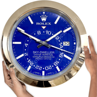 Hands holding a large round Rolex Sky-Dweller clock with a blue face, silver frame, and white hour markers, displaying the date 30 and showing the time at approximately 10:50:20
