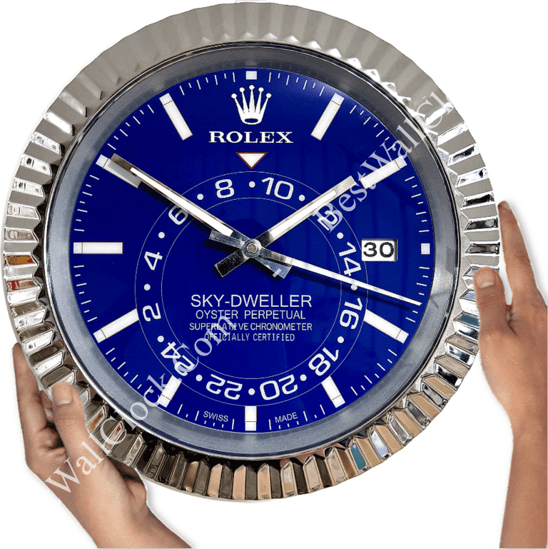 Hands holding a large wall clock designed to look like a blue Rolex Sky-Dweller wristwatch face with silver details and a date display at 3 o'clock