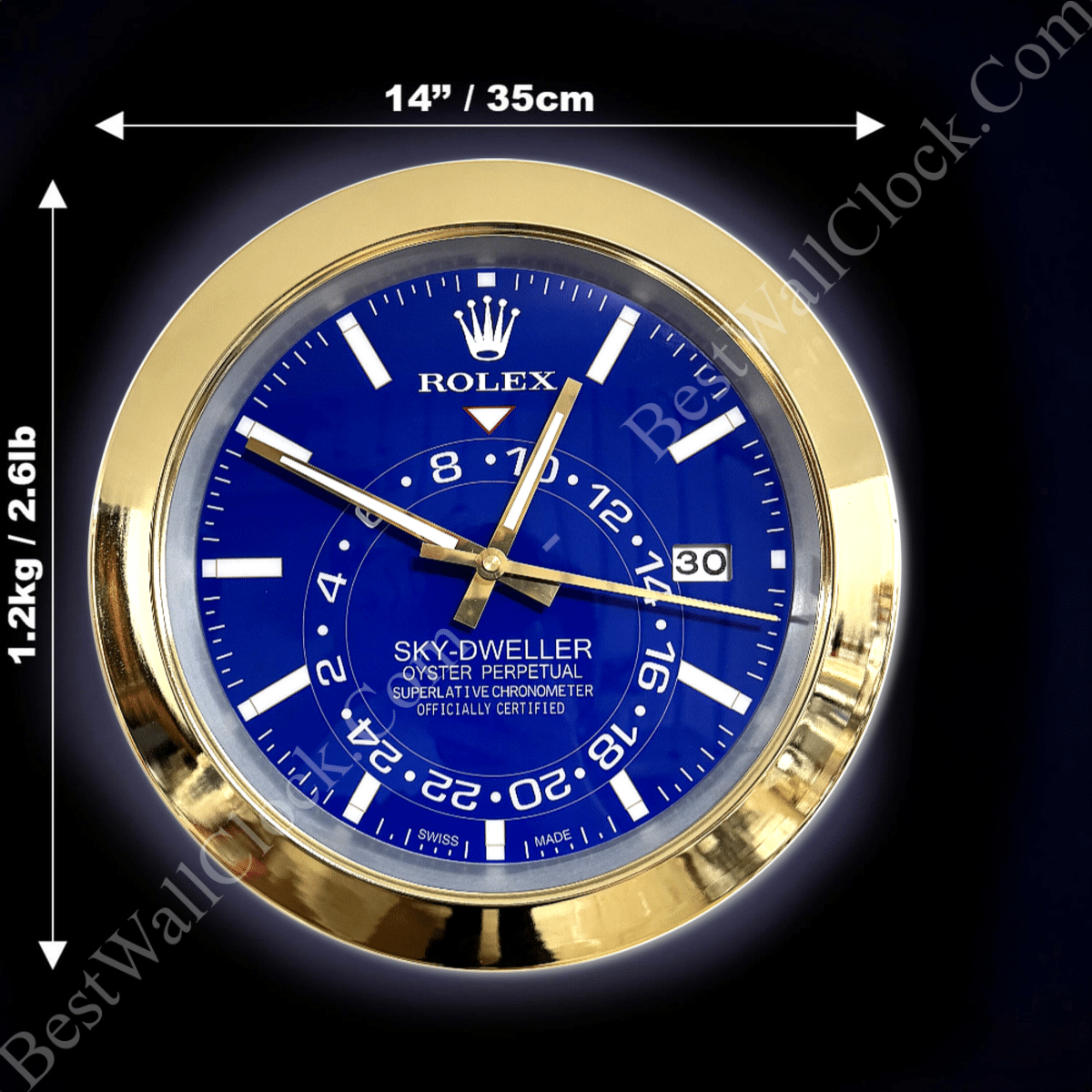 Rolex Sky-Dweller wall clock with a blue face and gold frame, showing hour, minute, and second hands, with date displayed at 3 o'clock and measurement labels indicating 14 inches (35 cm) diameter and weight 1.2 kg (2.6 lb) on a black background.