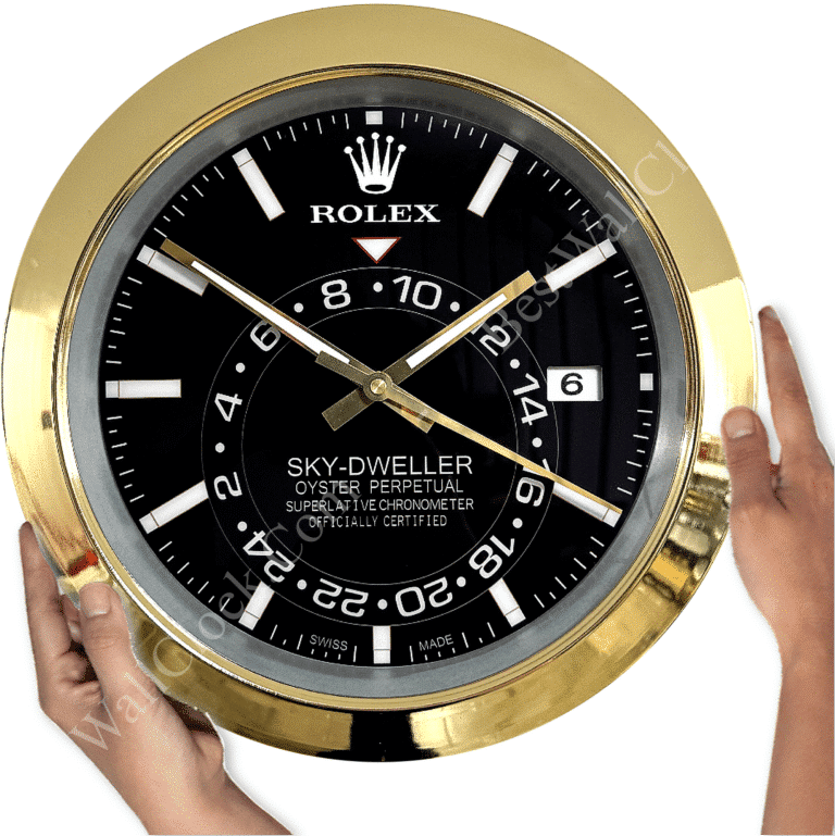 Close-up of a round wall clock designed to resemble a Rolex Sky-Dweller watch face, featuring a black dial with white and gold markings, gold hands, and a gold frame, held by two hands on either side