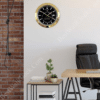 Modern office setup with a black and gold wall clock resembling a Rolex Sky-Dweller mounted on a white wall, next to a brick wall, above a small table with stacked books and two small potted plants, adjacent to a wooden desk and black leather office chair.