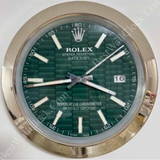 Close-up of a Rolex Oyster Perpetual Datejust wall clock with a green hexagonal pattern dial, silver hour markers and hands, gold outer rim, and date display showing 16.