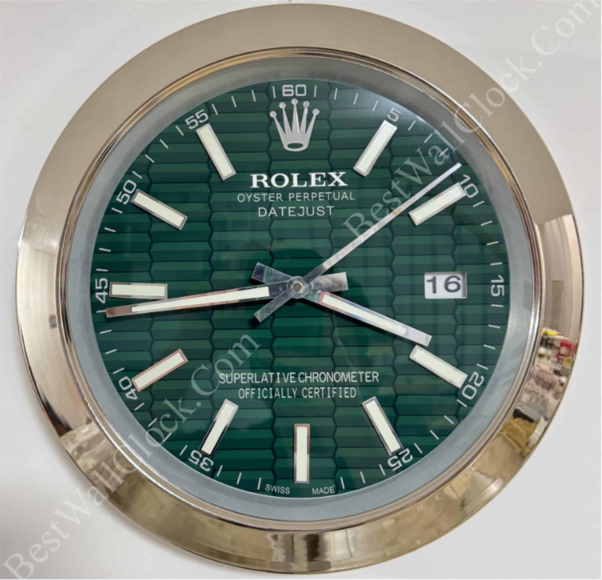 Close-up of a Rolex Oyster Perpetual Datejust wall clock with a green hexagonal pattern dial, silver hour markers and hands, gold outer rim, and date display showing 16.